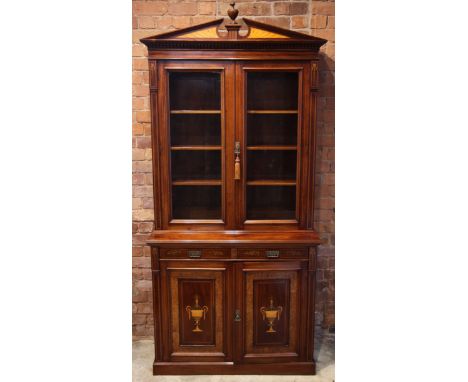 An Edwardian Sheraton revival mahogany library bookcase, the architectural pediment inlaid with satin wood bat wings, enclosi