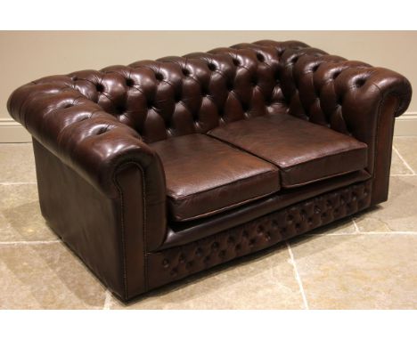 A nut brown leather two seater Chesterfield sofa, late 20th century, of typical deep set form with button down back rest and 