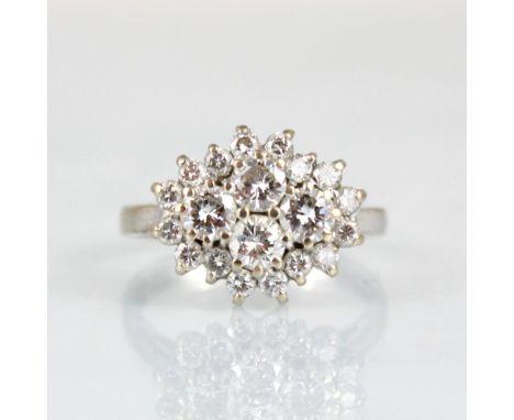 An 18ct white gold diamond cluster ring, the central quatrefoil round cut diamonds within surround of sixteen smaller round c