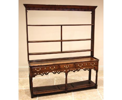A George III oak Welsh dresser, the moulded cornice and plain frieze applied with iron cup hooks over three open shelves, upo