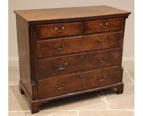 A George III oak chest of drawers, the crossbanded top over an arrangement of two short and three graduated long oak lined an