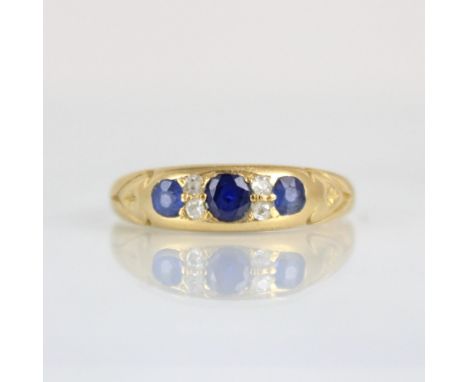 An early 20th century diamond and untested sapphire ring, the central cushion cut stone with old cut diamonds and further sma