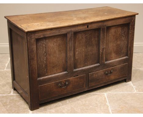 A mid 18th century oak mule chest, the hinged plank top over a three panel front and two lip moulded drawers, all upon stile 