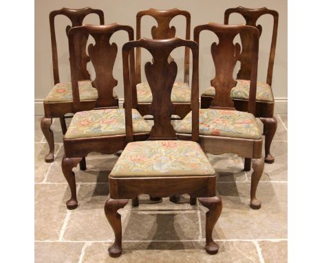 A set of six walnut George II style dining chairs, each with a vase shaped splat over a drop-in tapestry seat, shaped front a