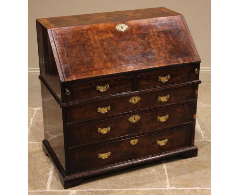 A George II burr walnut and feather banded bureau, the fall front opening to a compartmented interior with a central door fla