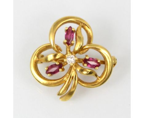An 18ct yellow gold ruby and diamond brooch, the trefoil stylised floral designed brooch with three ruby detail surrounding r
