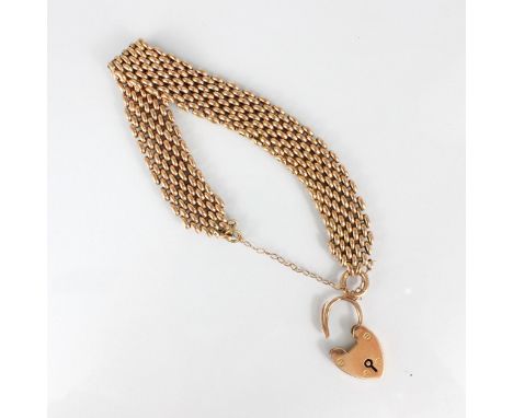 An early 20th century yellow metal gate link bracelet, suspending a heart shaped padlock fastener, stamped ‘MD 9ct’ 16gms
