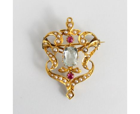An early 20th century untested aquamarine, ruby and seed pearl pendant/brooch, of sinuous design with central cushion cut unt