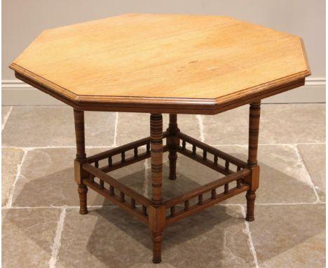 An Edwardian oak octagonal library table, by Collinson and Lock, London, the moulded octagonal top upon ring turned and ring 