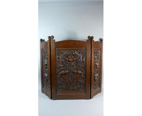 A Carved Oak Three Fold Fire Screen Decorated In Relief with Fruit, 77.5cm high 