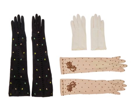 Three pairs of vintage gloves, owned by Elizabeth Taylor. The first pair are mid-length beige nylon gloves embellished with c