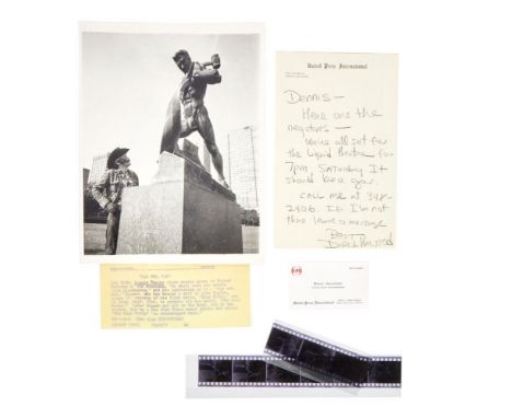 A black and white United Press International Photo (UPI) press photo of Dennis Hopper looking up at the Soviet sculpture "Let