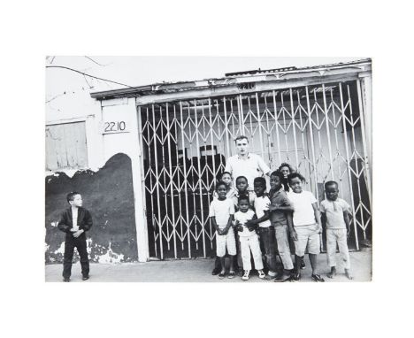 A black and white photograph of Dennis Hopper posing with a group of children, taken while he was in Selma, Alabama for the p