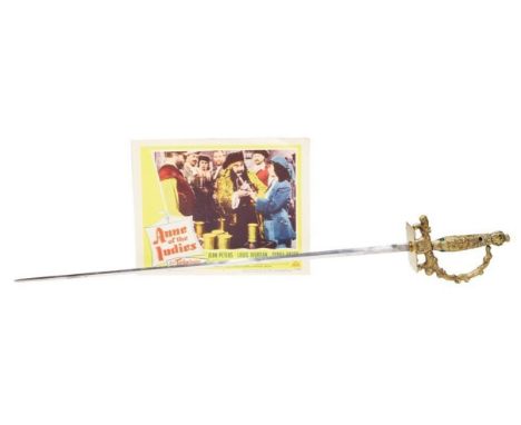 A gold-tone metal epee (fencing sword) and scabbard encrusted with simulated jewels that was used by actress Jean Peters in t