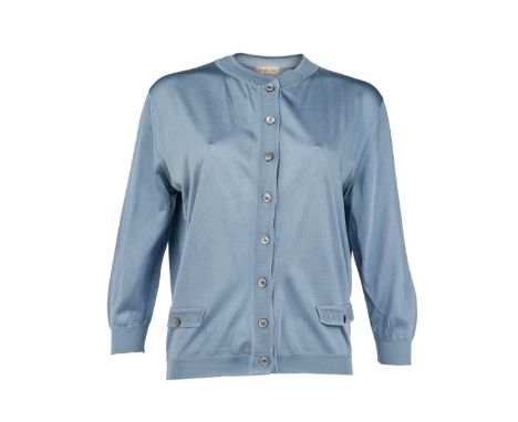 A vintage slate blue silk knit cardigan with pearlized buttons, owned by Elizabeth Taylor. The label reads “Christian Dior Tr