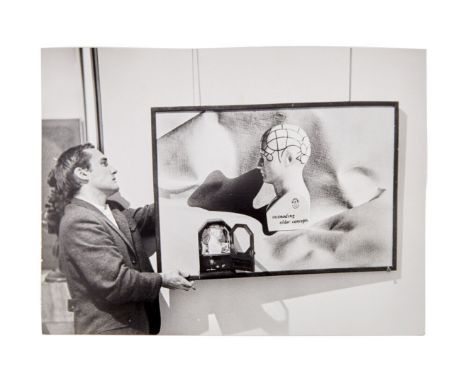A black and white photograph of Dennis Hopper hanging art at a David Stuart&nbsp;gallery in Los Angeles, taken by photographe
