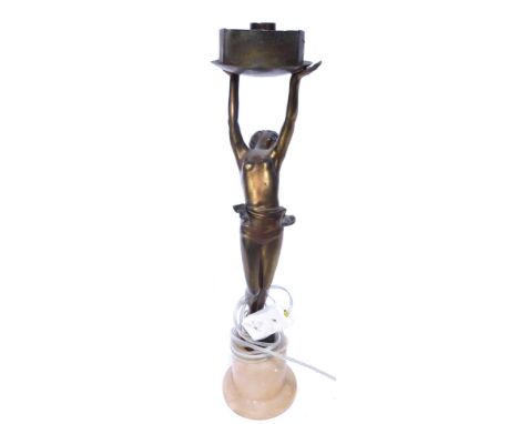 An Art Deco table lamp, of a semi nude female, holding the fitting aloft, on a pink onyx base, 44cm high. Buyer Note: WARNING