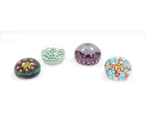 A vintage millefiori ink well paperweight, 8.5cm wide, and three further millefiori paperweights, of varying designs, each 7.