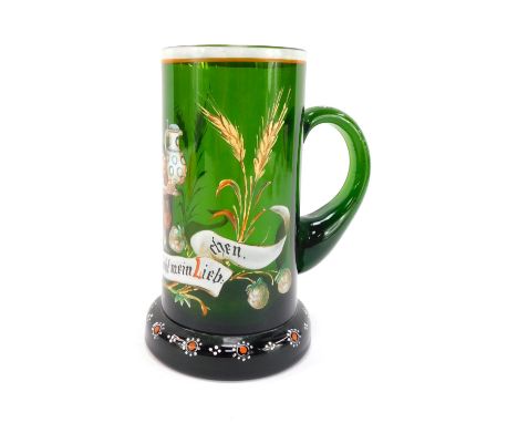 A late 19thC German green glass tankard, enamel decorated with an elfin figure holding a stein above a banner with hops and b