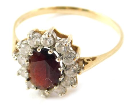 A 9ct gold floral cluster ring, with garnet and CZ stones, raised scroll shoulders, size S½, 2.5g all in.