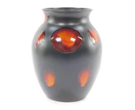 A Poole Pottery Galaxy vase, on a black ground with orange lustre streaks, 23cm high.