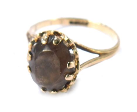 A 9ct gold smoky quartz dress ring, the oval smoky quartz with fluted outer border, on three strand V splayed shoulders, size