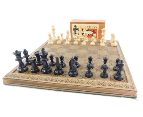 An early 20thC French cased wooden chess set, with a resin chess board, the king 5cm high. 