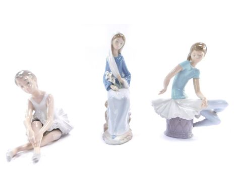 Three Lladro and Nao figures, comprising a Lladro figure of a seated ballerina, 21cm high, a Nao figure of a stretching seate