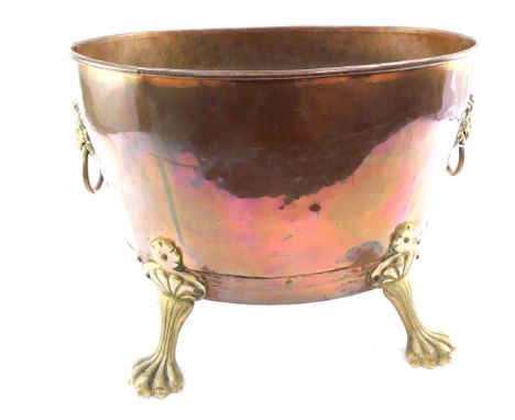 A Victorian copper and brass log basket, the shaped oval basket, on claw feet with lion mask and ring handles, 33cm high, 44c
