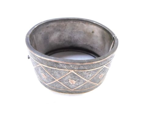 A Victorian silver hinged cuff bangle, of bicoloured design, with square set panels with tulips, 6.5cm diameter, 45g all in.