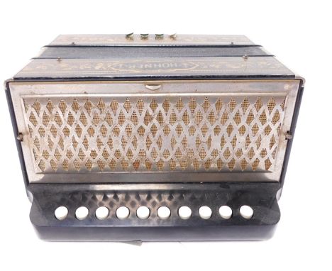 A Hohner accordion, ten button, in a gilt decorated black case.