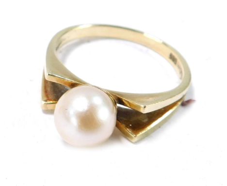 A cultured pearl dress ring, the central pearl with two bow design shoulders, size N½, 3.5g all in, boxed.