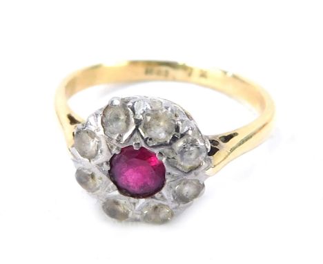 A ruby and diamond dress ring, the ruby surround by tiny diamonds in a platinum setting, with pierced design shoulders, yello