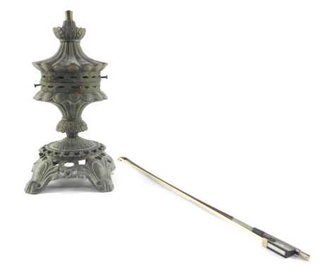 A Victorian cast metal oil lamp base, converted to electricity, shade lacking, together with a violin bow. (2)