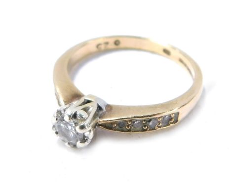 A 9ct gold diamond solitaire ring, with round brilliant cut claw set diamond, approx 0.10cts, with three tiny diamond set sho