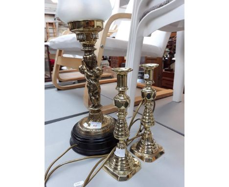 A brass figure lamp and a pair of brass candlesticks 