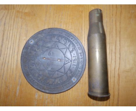 A reproduction brass sundial together with a 2" diameter brass shell case. (2)