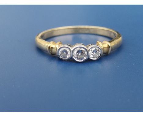 A modern collet set three stone diamond 18ct gold ring.  Finger size Q.