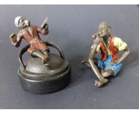 A cold-painted bronze figure of a young man smoking a pipe - 'Geschutzt', 2.5" and one other. (2)