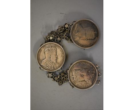 Coins:&nbsp;three Edward VII 'Straits Settlements' silver dollars, mounted as a cloak fastener, 97g total weight. 