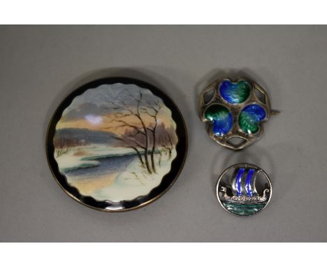 A large Scandinavian enamel and silver brooch; together with an Arts &amp; Crafts example; and one other. (3)