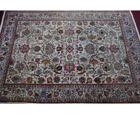 A Persian Tabriz carpet, all over floral motifs on a cream ground within floral borders, 320 x 214cm 