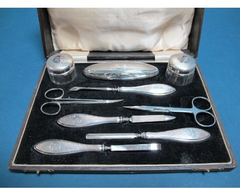 A Matched Hallmarked Silver Mounted Manicure Set, H&amp;HLd, Birmingham 1929, 1931, engine turned and initialled "NC", with a