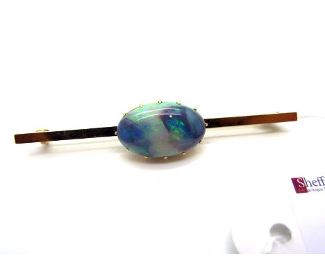 A Large Single Stone Opal Bar Brooch, oval claw set, on plain bar, 6.3cm long.