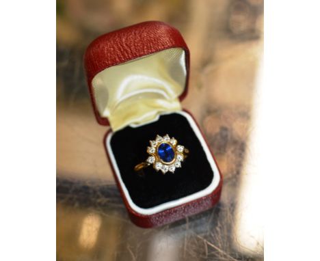 18 CARAT GOLD RING SET WITH A CENTRAL SAPPHIRE &amp; 12 STONE DIAMOND SURROUND - APPROXIMATE WEIGHT = 6.7 GRAMS     