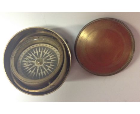 A 19th century brass gimbal compass, 4.2cm  paper disc register with four cardinal and four ordinal directions, within deline