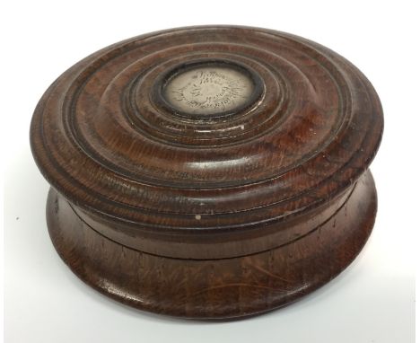 An early Victorian turned oak waisted circular snuff box, push-fitting cover with silver coloured metal roundel inscribed Fra