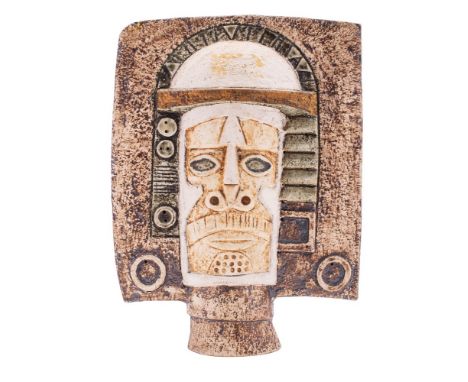 A Troika pottery mask, of double faced spade form the textured ground with ivory, brown and green staining, painted Troika ma