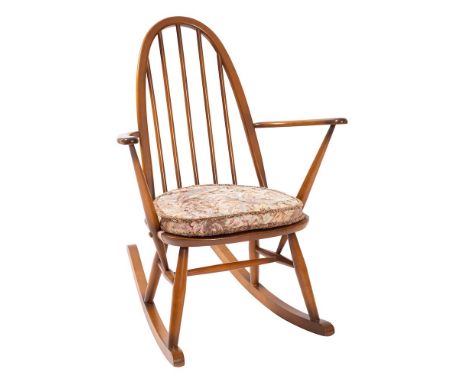 An Ercol elm and beech 'Quaker' rocking chair, early 1980s; with arched spindle back and open arms; with original fabric cush