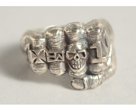 A SILVER RING WITH FIST AND SKULLS.